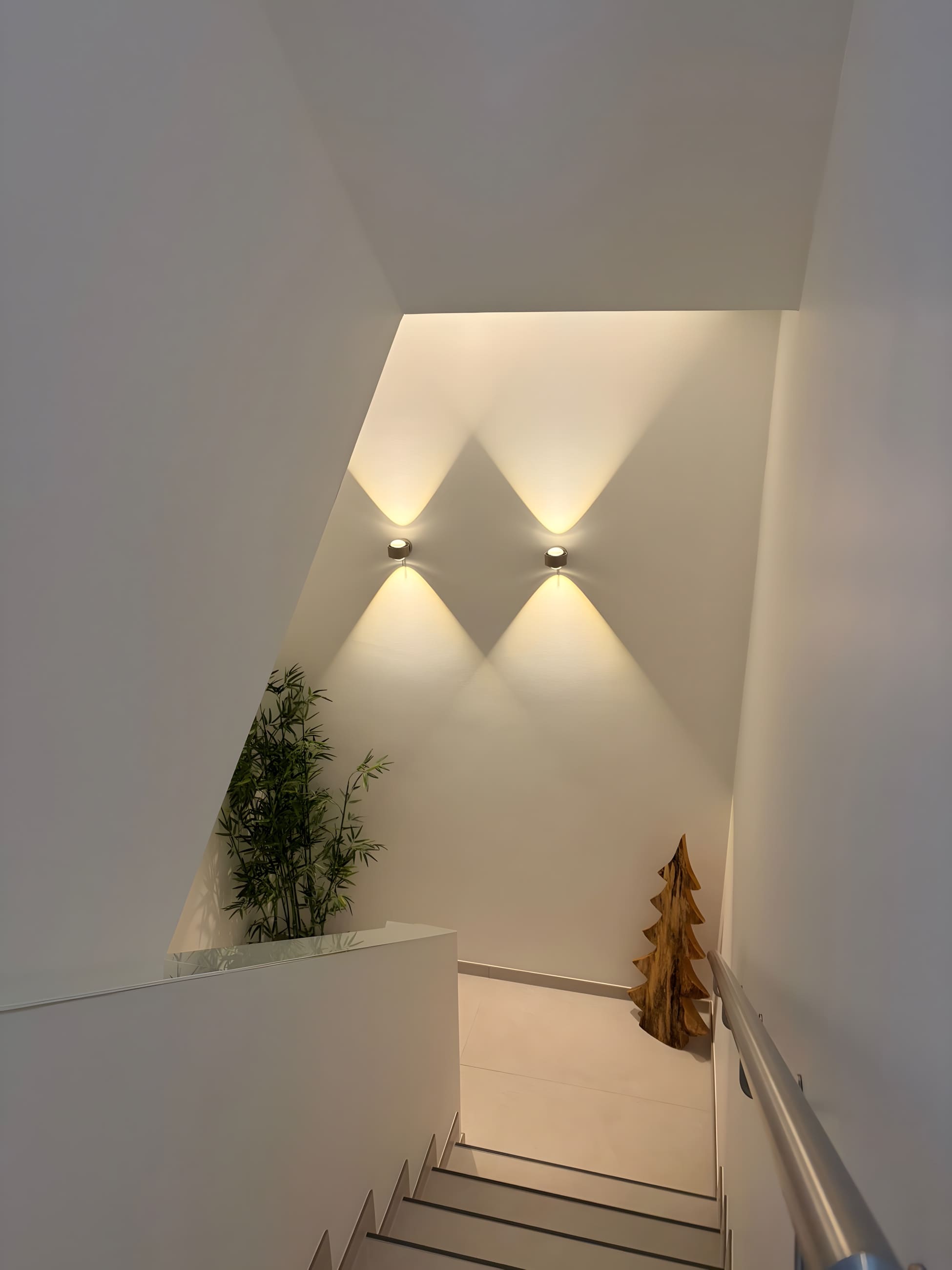 Premium-Treppenhaus mit dezenten Wandleuchten in einem Designneubau